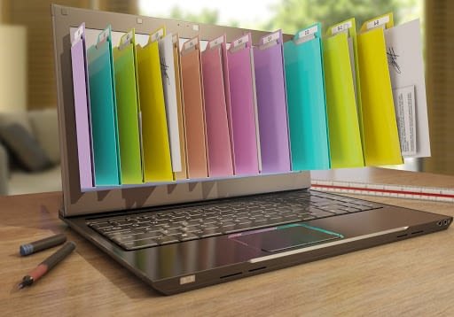 Image of a laptop with various colors of photos coming out of the screen.
