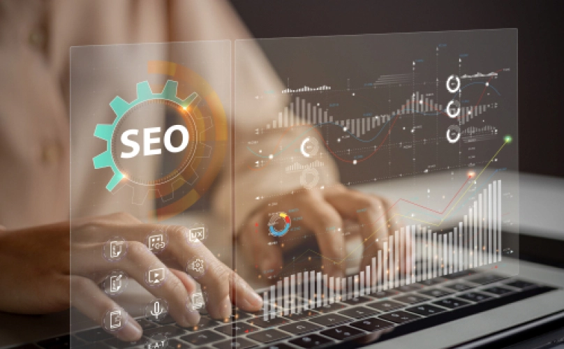 Hands typing on a keyboard. The screen reads "SEO".